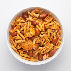 Close-Up of Spicy Chatpata Mixture in a white Ceramic bowl made with peanuts, corn flakes. Indian spicy snacks (Namkeen), Top View