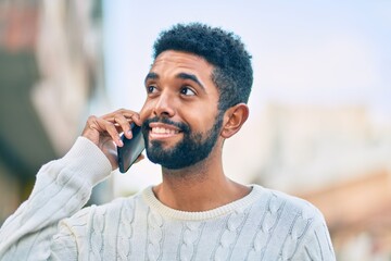 Young african american man smiling happy talking on the smartphone at the city.