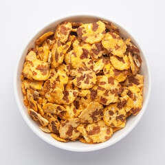 Spicy Chana Jor Garam in a white Ceramic bowl, made with air-fried Bengal Chickpea. Pile of Indian spicy snacks (Namkeen), Top View