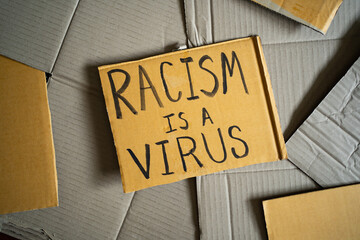 Racism is a virus was written on a cardboard