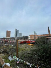 City view with modern buildings in the background and a construction site in the foreground. Taken in Manchester England. 