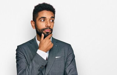 Young african american man wearing business clothes with hand on chin thinking about question, pensive expression. smiling with thoughtful face. doubt concept.