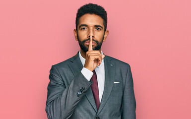 Young african american man wearing business clothes asking to be quiet with finger on lips. silence...