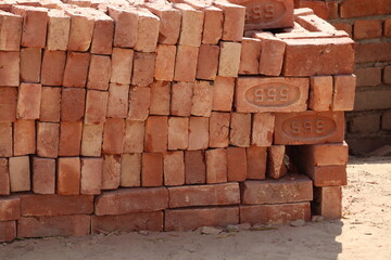 New Delhi, Delhi India- March 07 2021: A structure of orange bricks and the unconstructed wall of low quality construction material.