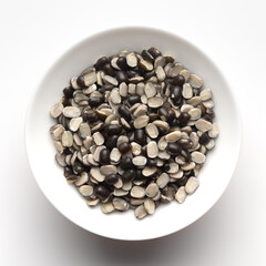 Macro Close up of Organic split black urad dal (Vigna mungo) with shell inside a ceramic white bowl. Top view 