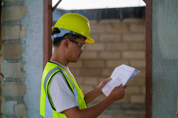 Foreman working in modern house building with notebook