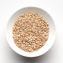 Macro Close up of Organic White Sesame seeds(Sesamum indicum) or white Til with shell inside a white ceramic bowl