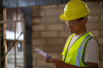 Fototapeta premium Foreman working in modern house building with notebook