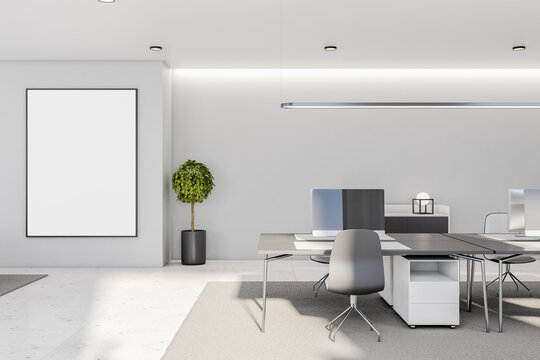 White poster with copyspace in black picture frame on light wall in modern interior designed coworking office with carpet on marble floor and stylish tables and chairs. Mock up