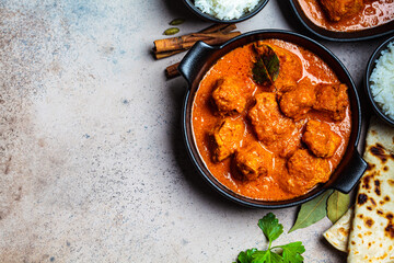 Chicken curry with rice and chapati bread, dark background, top view, copy space. Indian cuisine concept.