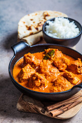Chicken curry with rice and chapati bread, dark background, close up. Indian cuisine concept.