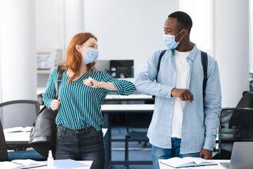 Diverse multicultural people wearing face masks greeting and bumping elbows