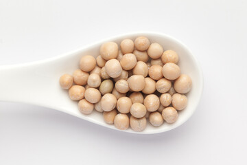Macro Close up of Close up of Organic dry peas whole (Pisum sativum) or matar dal on a white ceramic soup spoon. Top view