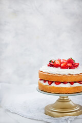 Victoria`s sponge cake, delicious homemade vanilla cake decorated with whipped cream and fresh strawberries