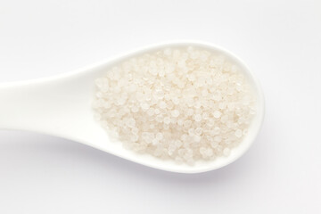 Macro Close up of organic white sago or sabudana small size on a white ceramic soup spoon. Top view