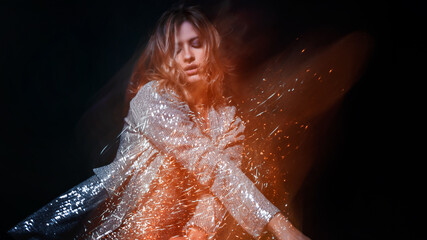 Attractive dancing blonde in the club, shining golden light, motion effects.