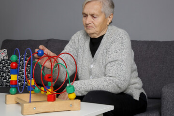 Senior woman preventing Alzheimer’s disease and dementia—or slowing its progress by supporting learning and memory through game.