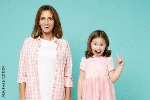 Happy woman in pink clothes child baby girl 5-6 years old Mommy little kid daughter hold index finger up with great new idea isolated on pastel blue background studio Mother's Day love family concept