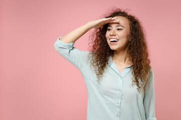 Young black african american fun happy optimistic expectant friendly curly woman 20s in blue shirt...