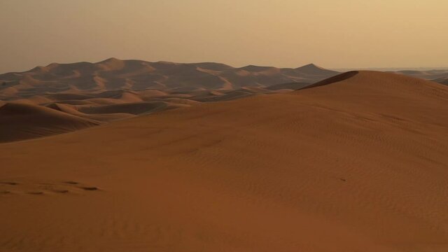 Landscape of desert dunes at sunset on a windy day