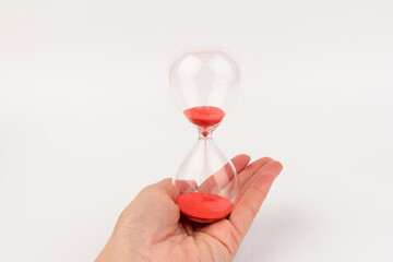Hand holding a hourglass isolated on white background