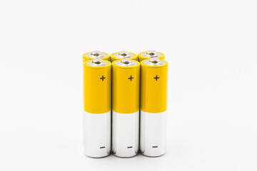 Photo of gray-yellow alkaline AA batteries on white background. Recycling of rechargeable NiMH...