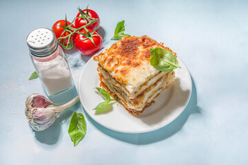 Mediterranean food, Italian traditional lasagna pasta, with bolognese, bechamel and cheese. On trendy breght light blue background with hard light and dark shadows copy space