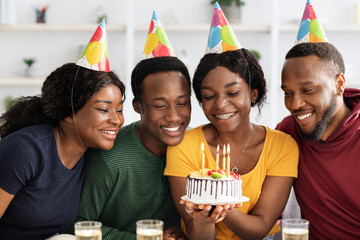 Group of happy black friends having birthday celebration at home