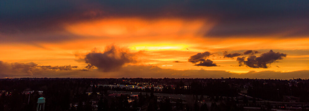 Dramatic Sunset With Vibrant Orange Sky Over Dark City Of Everett, Washington