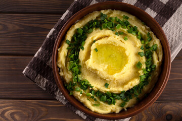 Champ is an Irish dish. Mashed potatoes with green onions. Wooden background.