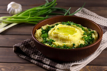 Champ is an Irish dish. Mashed potatoes with green onions. Wooden background.