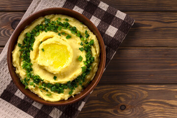 Champ is an Irish dish. Mashed potatoes with green onions. Wooden background.