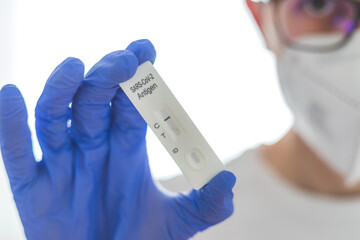 Young biologist or pharmacist is holding a covid-19 or corona antigen test