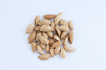 A handful of  bunch of berry nuts in shells on a white background.
