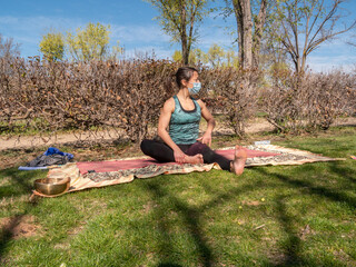 BRUNETTE WOMAN DOING YOGA IN PARK