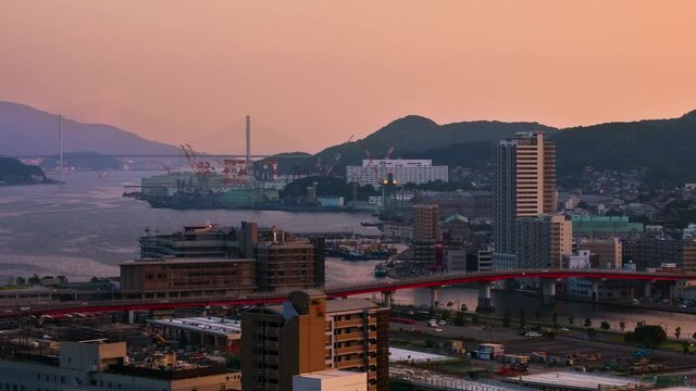 Nagasaki, Japan. A sunset timelapse made from a hill in Nagasaki, Japan, with a view over the entire center, including the bay and the hills, panning video