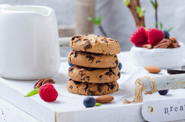 Breakfast with cookies and fresn berries  on a white wooden tray.