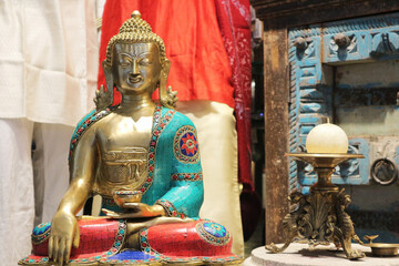 A statuette of a bronze meditating Buddha.