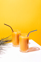 Glass of fresh mango juice cocktail and palm branches