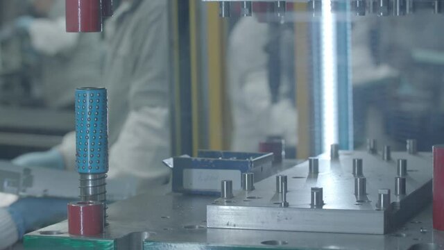 Persona tomando placa de metal de una maquina