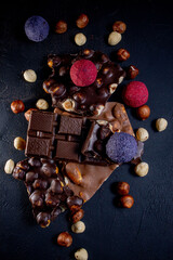 Chocolate bar, crushed pieces of dark chocolate and nuts. Praline Chocolate sweets