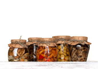 homemade pickled mushrooms in a glass jar on White background. Canned mushrooms close up, copy space;