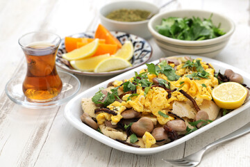 iraqi breakfast; boiled dried broad beans and scrambled eggs over pieces of flatbread ( bagila bil dihin )