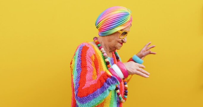 Footage of a funny grandmother with fashionable look acting on colored backgrounds