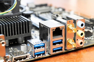 Close up of a desktop computer motherboard. LAN connectors, USB, audio ports