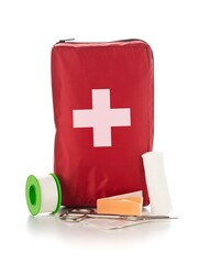 Red first aid medical kit bag with scissors, tape and gloves standing over white