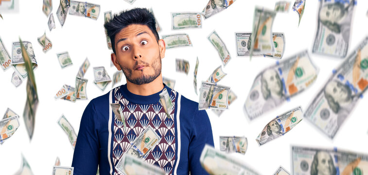 Handsome latin american young man wearing casual winter sweater making fish face with lips, crazy and comical gesture. funny expression.
