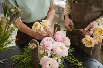Close up of beautiful flower composition with roses and peonies on table in florist workshop, copy space