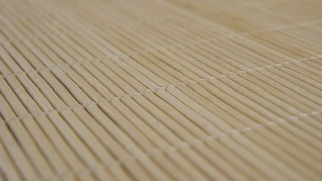 Wicker Asian traditional bamboo mat close-up. Macro. Dolly shot. Empty textured surface