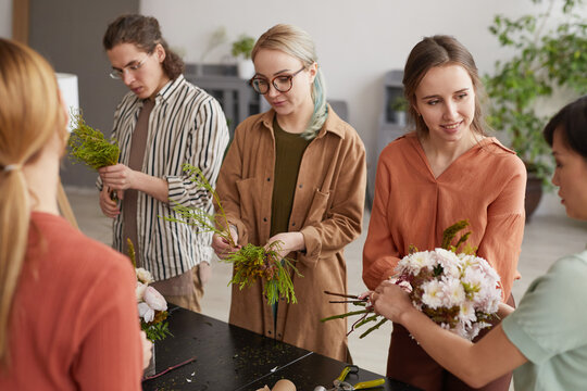 High angle portrait of diverse group of young people attending class on floral art in florists workshop
